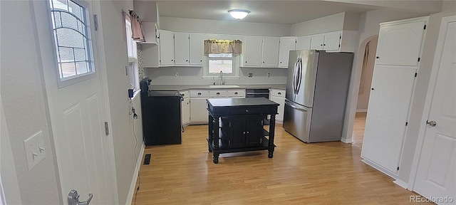 315 W 5th St, Julesburg, CO 80737 - kitchen with white cabinets, a sink, freestanding refrigerator, dishwashing machine, and light wood finished floors