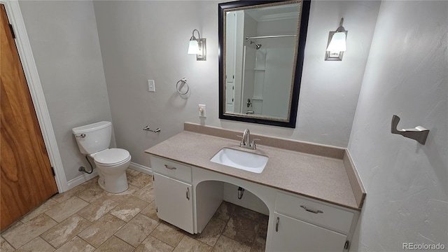 315 W 5th St, Julesburg, CO 80737 - full bath with vanity, baseboards, stone finish flooring, toilet, and a shower