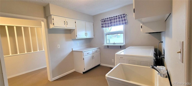 315 W 5th St, Julesburg, CO 80737 - washroom featuring a textured ceiling, separate washer and dryer, a sink, baseboards, and cabinet space