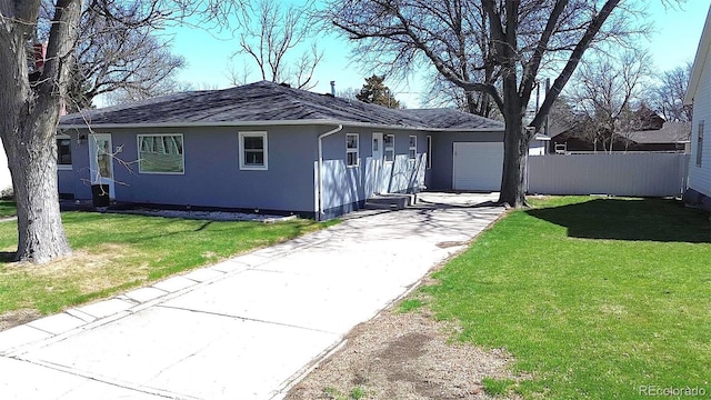 315 W 5th St, Julesburg, CO 80737 - single story home featuring a front yard, an attached garage, fence, concrete driveway, and stucco siding