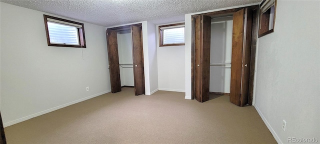 315 W 5th St, Julesburg, CO 80737 - unfurnished bedroom with baseboards, multiple windows, light colored carpet, and a textured ceiling