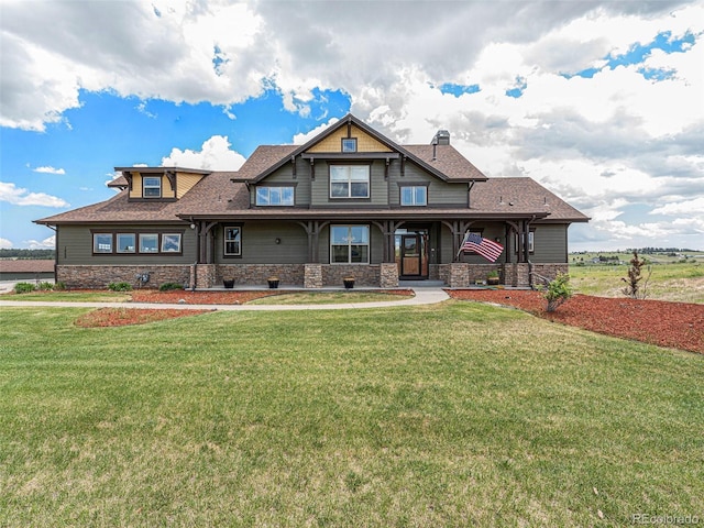 view of front of property with a porch, a front yard, stone siding, and roof with shingles