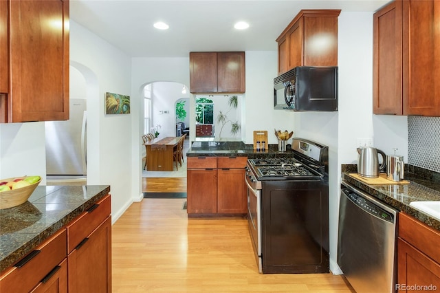 kitchen featuring stainless steel appliances, light hardwood / wood-style flooring, and tasteful backsplash