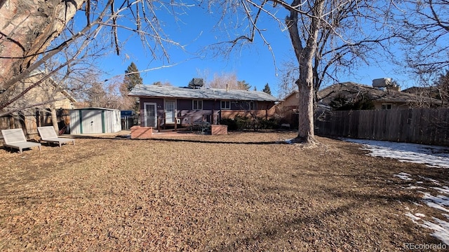 back of house featuring a shed