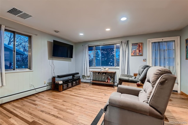 living room featuring a baseboard heating unit and light hardwood / wood-style floors