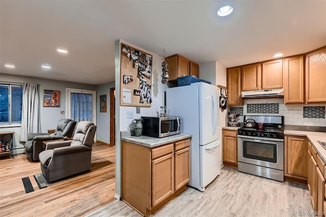 kitchen with light wood-type flooring, stainless steel appliances, a baseboard heating unit, and backsplash