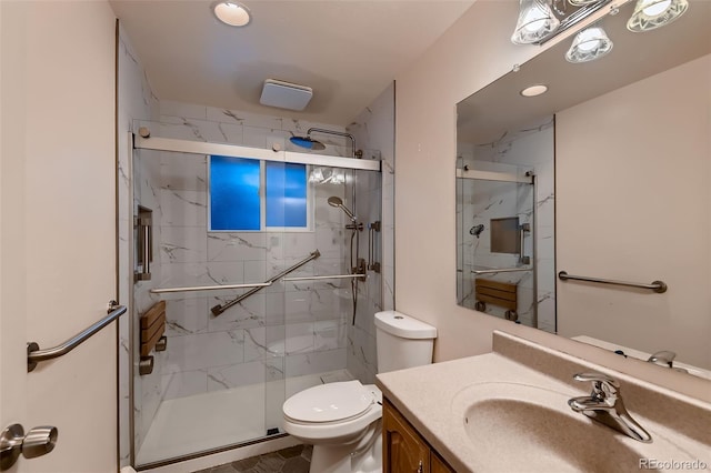 bathroom featuring a shower with door, toilet, and vanity