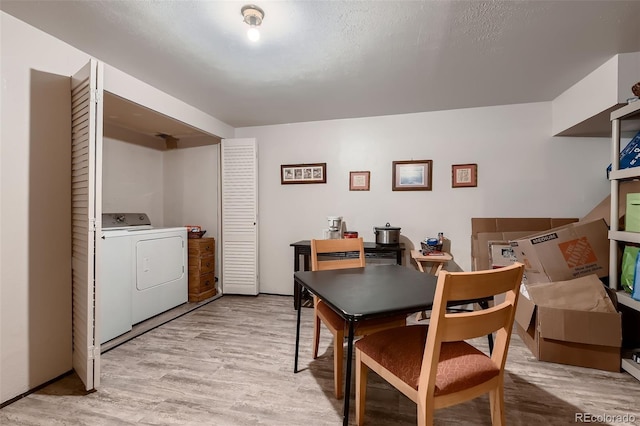 dining area with washer / dryer, light hardwood / wood-style floors, and a textured ceiling