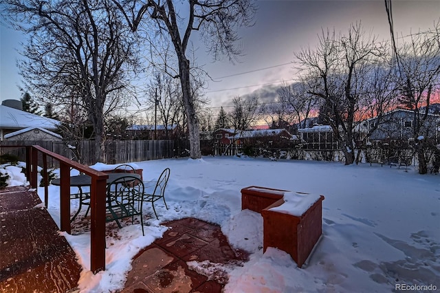 yard covered in snow with a playground