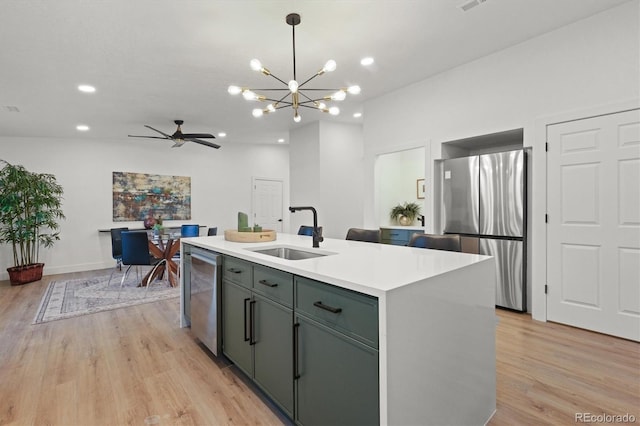 3025 Ivanhoe St, Denver, CO 80207 - kitchen with appliances with stainless steel finishes, light wood-style flooring, light countertops, a chandelier, and recessed lighting