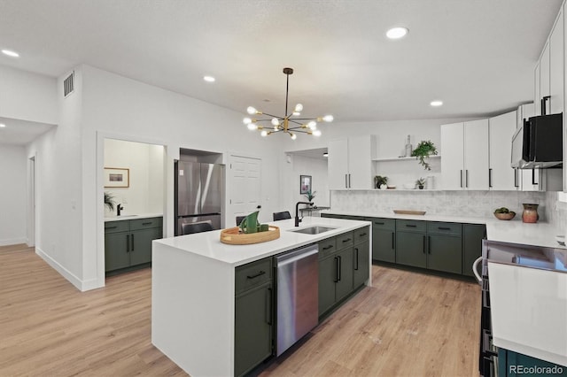 3025 Ivanhoe St, Denver, CO 80207 - kitchen featuring appliances with stainless steel finishes, open shelves, a chandelier, an island with sink, and backsplash