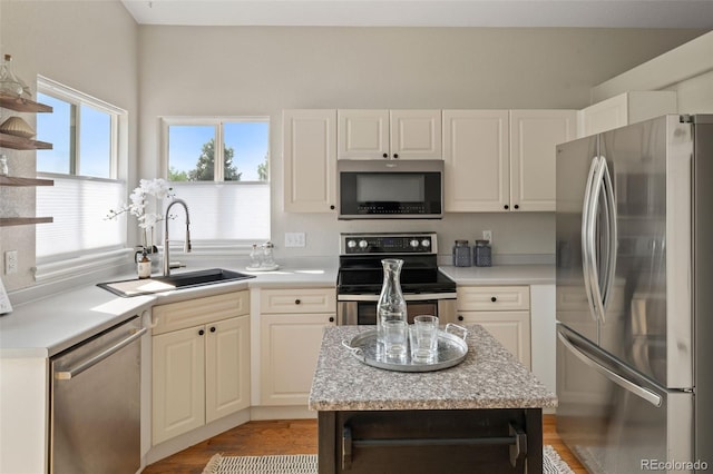 9698 Queenscliffe Dr, Highlands Ranch, CO 80130 - kitchen featuring appliances with stainless steel finishes, a sink, white cabinets, and light wood-style flooring