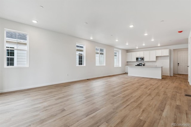 19110 E 96th Pl, Commerce City, CO 80022 - unfurnished living room with recessed lighting, light wood finished floors, and baseboards