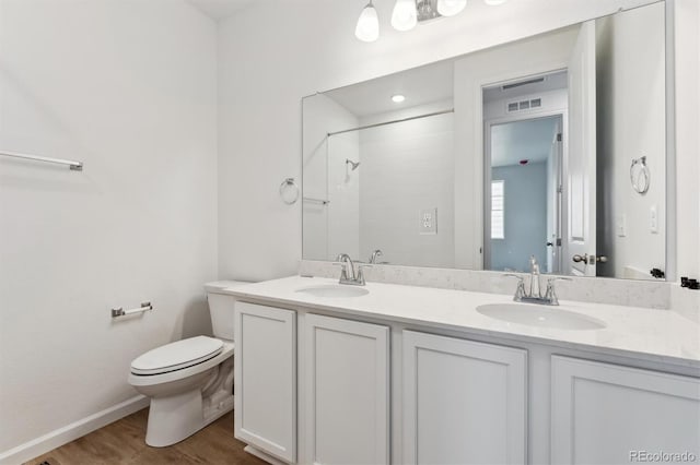 19110 E 96th Pl, Commerce City, CO 80022 - full bath featuring toilet, a shower, wood finished floors, double vanity, and baseboards