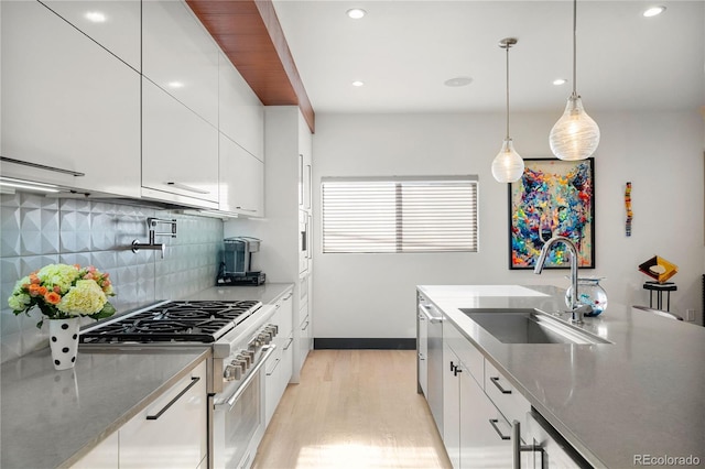 kitchen featuring sink, hanging light fixtures, tasteful backsplash, white cabinets, and appliances with stainless steel finishes