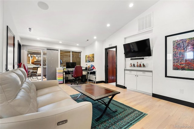 living room featuring light hardwood / wood-style flooring and vaulted ceiling