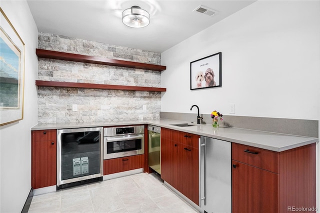 kitchen with refrigerator, sink, oven, and beverage cooler