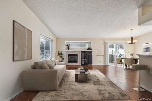 11565 Decatur St Unit 7D, Denver, CO 80234 - living room with a textured ceiling, healthy amount of natural light, hardwood / wood-style flooring, a chandelier, and a fireplace