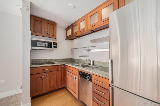 1020 15th St Unit 18I, Denver, CO 80202 - kitchen featuring stainless steel appliances, a sink, brown cabinetry, and glass insert cabinets
