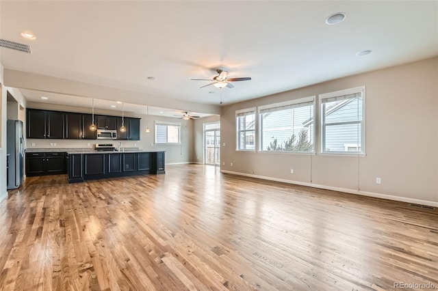 unfurnished living room with ceiling fan and light wood-type flooring