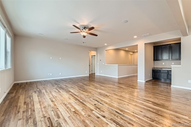 unfurnished living room featuring ceiling fan and light hardwood / wood-style floors