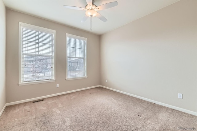 spare room featuring ceiling fan and carpet