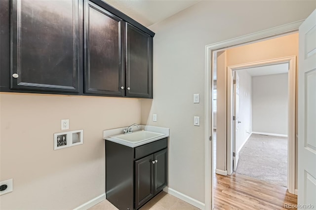 clothes washing area featuring cabinets, hookup for an electric dryer, washer hookup, sink, and light hardwood / wood-style flooring