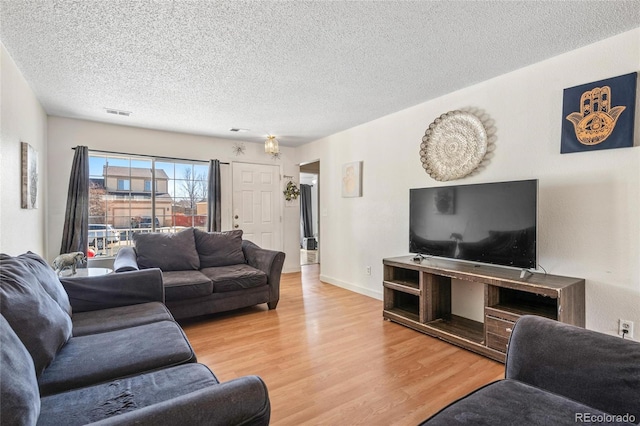 15627 E 51st Dr, Denver, CO 80239 - living area with light wood-style flooring, baseboards, and a textured ceiling