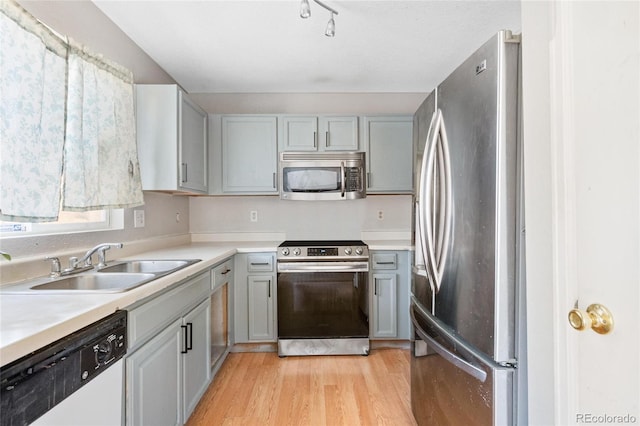 15627 E 51st Dr, Denver, CO 80239 - kitchen with stainless steel appliances, light countertops, light wood-style flooring, gray cabinetry, and a sink