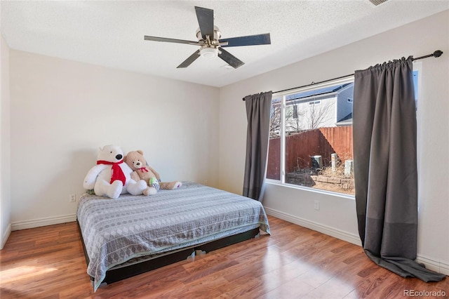 15627 E 51st Dr, Denver, CO 80239 - bedroom featuring a ceiling fan, a textured ceiling, baseboards, and wood finished floors
