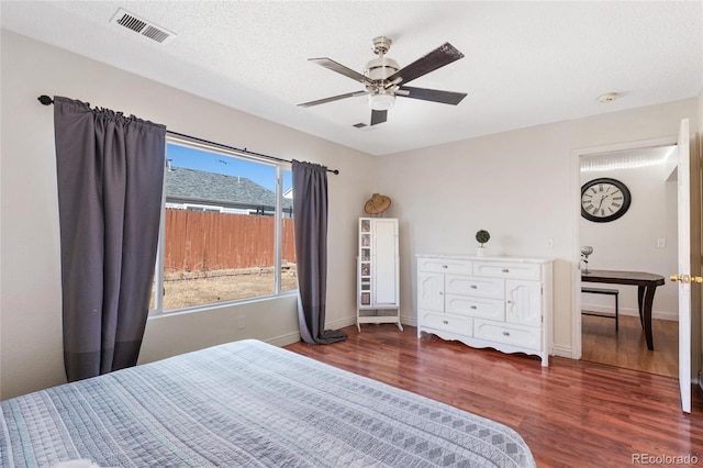 15627 E 51st Dr, Denver, CO 80239 - bedroom featuring a textured ceiling, wood finished floors, visible vents, and baseboards