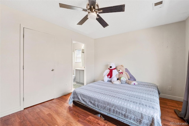 15627 E 51st Dr, Denver, CO 80239 - bedroom featuring baseboards, visible vents, wood finished floors, and ensuite bathroom
