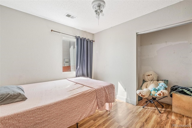 15627 E 51st Dr, Denver, CO 80239 - bedroom with baseboards, a textured ceiling, visible vents, and wood finished floors