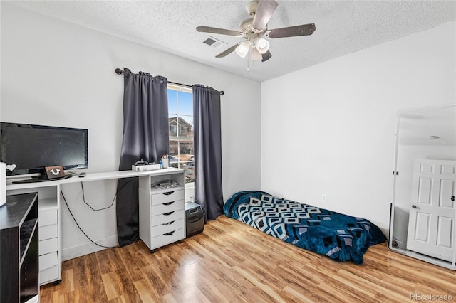 15627 E 51st Dr, Denver, CO 80239 - bedroom featuring a textured ceiling, ceiling fan, wood finished floors, and visible vents