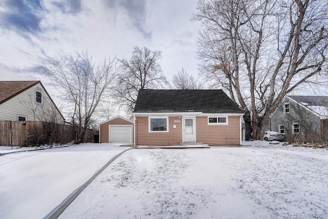 view of front of home featuring a garage and an outbuilding