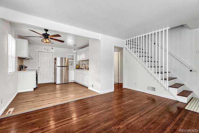 unfurnished living room featuring ceiling fan and wood-type flooring