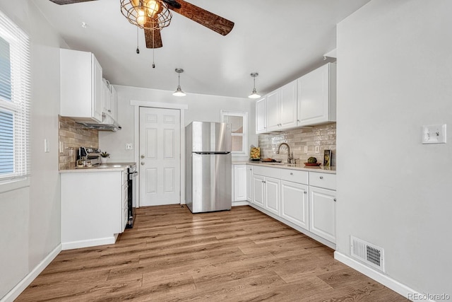 kitchen featuring appliances with stainless steel finishes, sink, white cabinetry, and pendant lighting