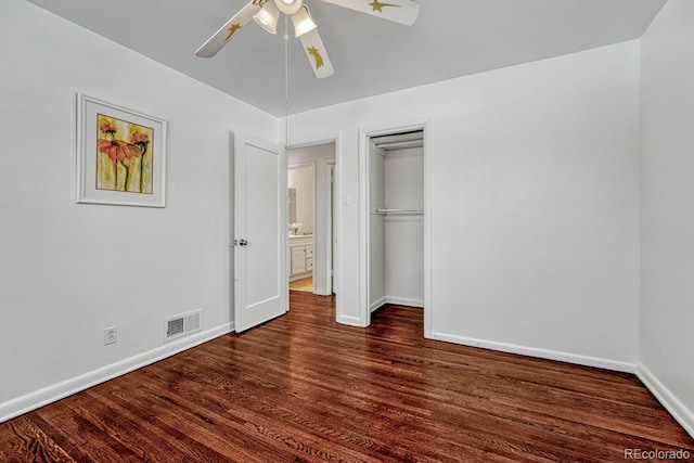 unfurnished bedroom with ceiling fan, dark wood-type flooring, and a closet