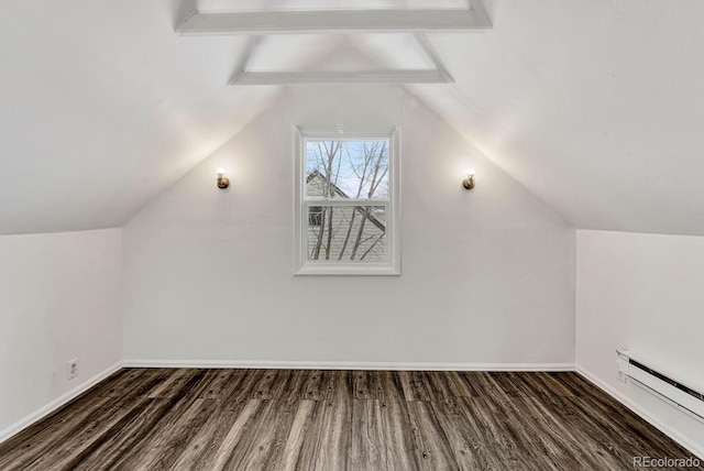 additional living space featuring a baseboard heating unit, dark hardwood / wood-style flooring, and vaulted ceiling with beams