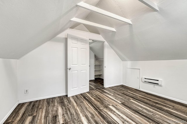 additional living space featuring a textured ceiling, dark hardwood / wood-style flooring, lofted ceiling, and a wall mounted air conditioner