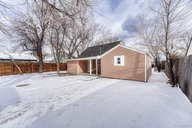 view of snow covered rear of property