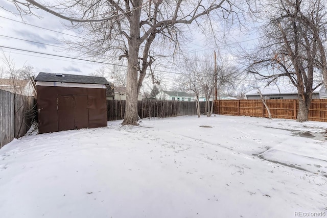 yard covered in snow with a shed