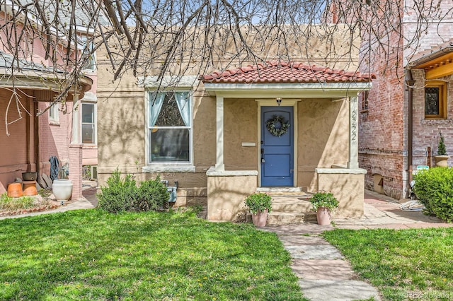 2222 N Williams St, Denver, CO 80205 - mediterranean / spanish-style house featuring a tiled roof, a front lawn, and stucco siding
