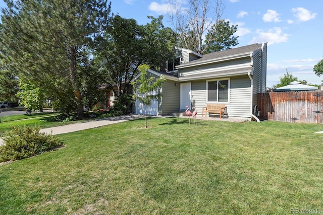 view of front of home with a garage, a front yard, driveway, and fence