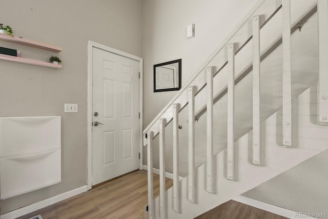 foyer featuring wood finished floors and baseboards