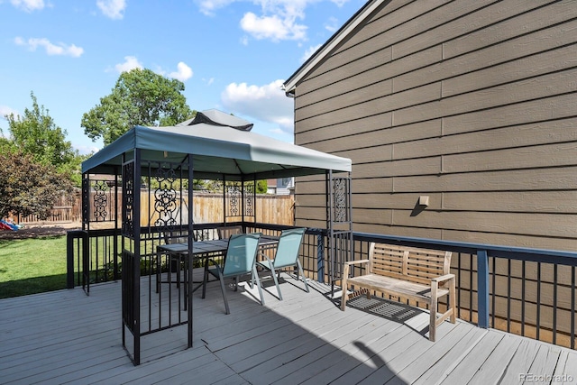 deck featuring a gazebo, outdoor dining area, and fence