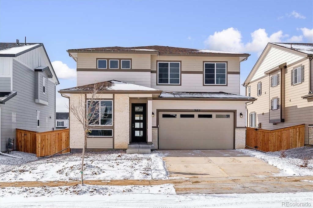 view of front of house with a garage, brick siding, fence, and driveway