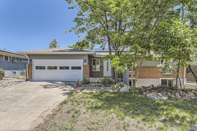 540 Ithaca Dr, Boulder, CO 80305 - view of front facade featuring brick siding, concrete driveway, and an attached garage