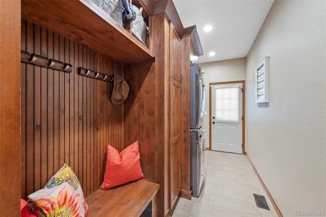 mudroom with stacked washer and clothes dryer, baseboards, visible vents, and recessed lighting