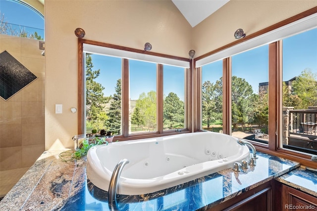 full bath featuring vaulted ceiling and a jetted tub